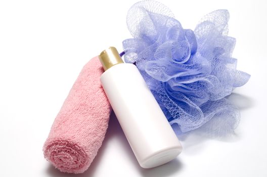 purple bath puff liquid soap and pink towel on a white background
