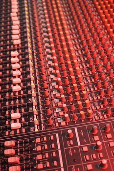 studio soundboard under red lighting