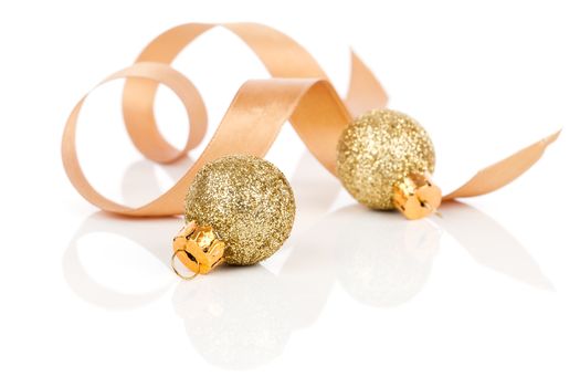 two golden christmas decoration balls with satin ribbon, isolated on white background