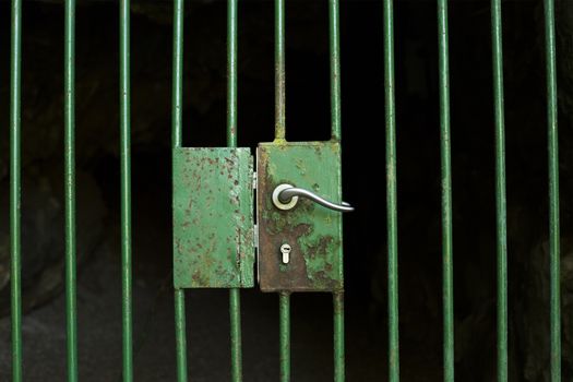 Cage door handle, protecting an entrance to a cave.