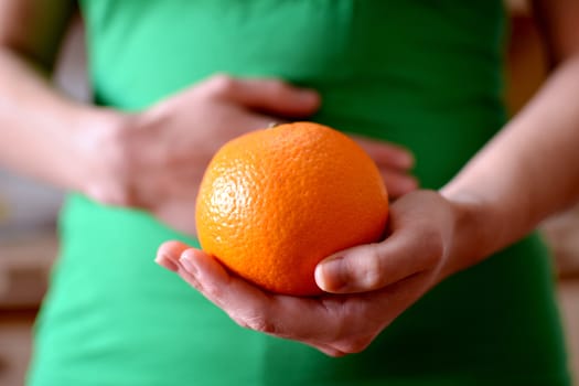 hand holding nice orange, give yourself one and enjoy it and have a better health.