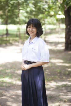 Asian female student Smiling and standing in the park.
