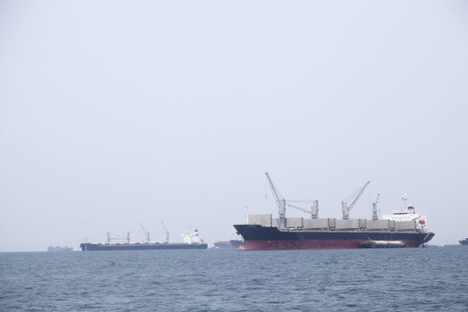 Large cargo ship Boats moored in the sea to make sense compared to the coast.