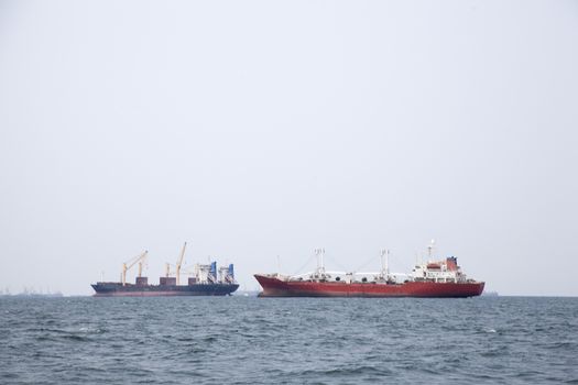 Large cargo ship Boats moored in the sea to make sense compared to the coast.