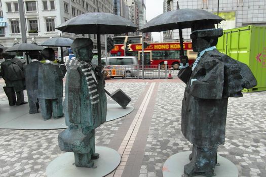 Sculpture of two people standing under umbrellas