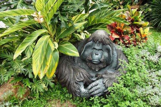 sculpture of a monkey with flowers in park