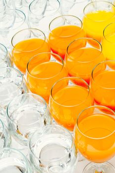 many glasses of juice and water on buffet table