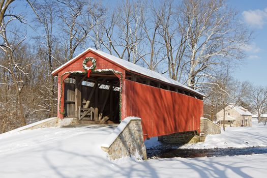 Pool Forge Covered Bridge with snow on a bright winter day in Lancaster County, Pennsylvania, USA.