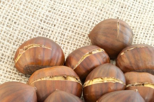 raw natural macro of chestnuts in jute background