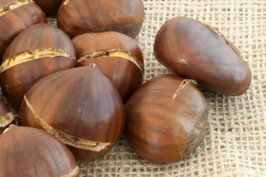 raw natural macro of chestnuts in jute background