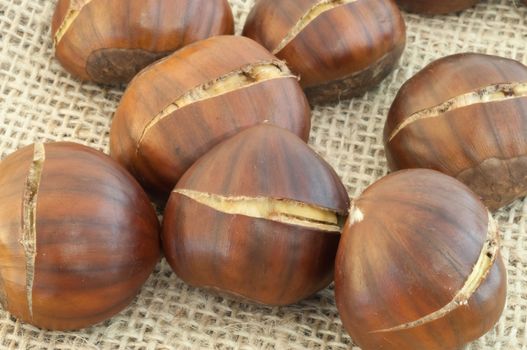 raw natural macro of chestnuts in jute background