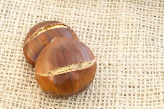 raw natural macro of chestnuts in jute background