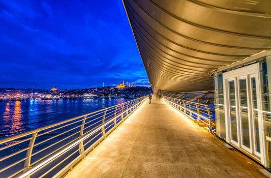 New Galata Bridge over Golden Horn with Istanbul night cityscape as background.