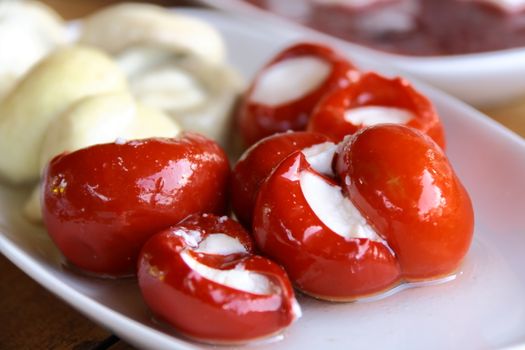 cheese in red pepper at Turkish breakfast on white table close up