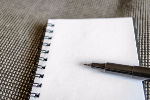 White notepad and ink pen on the wooden desk