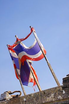 photo of Tattered Thailand flag over blue sky