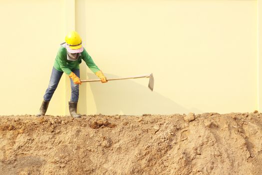 Laborer digging with hoe on construction site