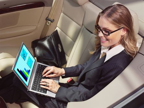 businesswoman has a fan with laptop in black car 