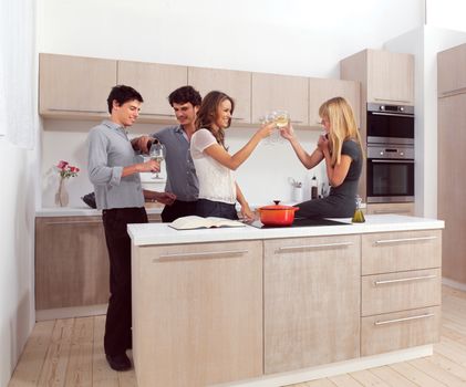 Group of friends preparing dinner in home kitchen 