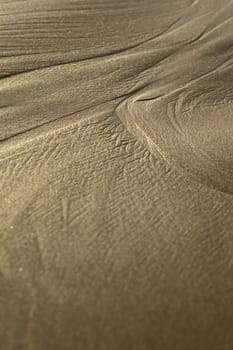 Lines formed by the water on sandy beach in the small town of Mancora in Northern Peru (Selective Focus, Focus two thirds into the image where the line branches out into two) 