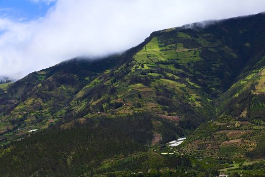 Rural hillside landscape with forests, small farms and orchards along the road between Ambato and Banos in Tungurahua Province in Central Ecuador. Even though the area lies relatively high (around 1800-2000 meters), many fruits and vegetables are being grown here.