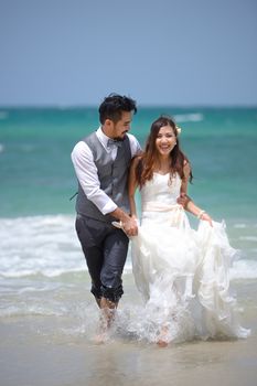 happiness and romantic scene of love just married young couple walking and at beautiful beach