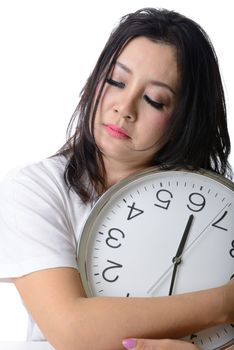 Sleepy asian woman hug the clock. Isolated on white background