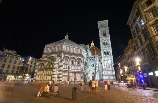 Pisa, Italy - August 11, 2013: Tourists in front of Cathedral Santa Maria del Fiore and the tower bell at night in Florence, Italy
