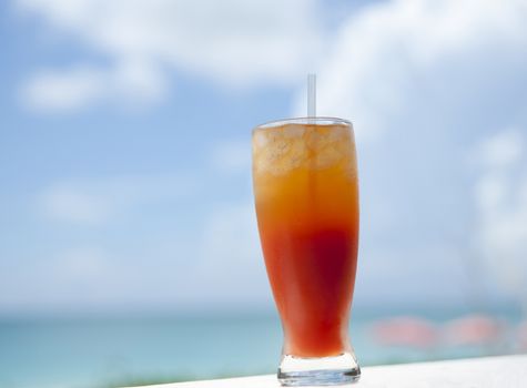 Caribbean cocktail, layered colors in frosty tall glass.