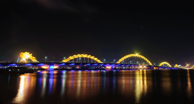 Reflection of Dragon bridge in to Han river at night, Danang city, Central of Viet Nam, SouthEast Asia