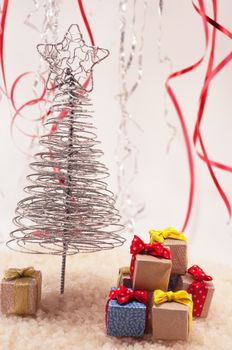 Christmas tree with presents on snow and colored fiefs