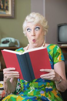 Startled Caucasian woman reading hard cover book
