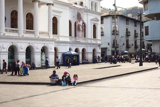 QUITO, ECUADOR - AUGUST 4, 2014: Unidentified people sitting and walking on the Plaza del Teatro (Theater Square) in front of the Sucre Theater in the historic city center on August 4, 2014 in Quito, Ecuador. Quito is an UNESCO World Cultural Heritage Site.