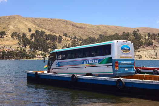 TIQUINA, BOLIVIA - OCTOBER 10, 2014: Bus being transported on wooden ferry over the Strait of Tiquina at Lake Titicaca on October 10, 2014 in San Pablo de Tiquina, Bolivia