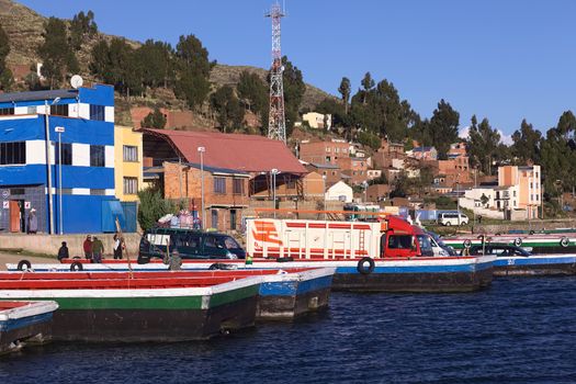 TIQUINA, BOLIVIA - OCTOBER 16, 2014: Truck and minibus on wooden ferry waiting to be transported over the Strait of Tiquina at Lake Titicaca on October 16, 2014 in San Pablo de Tiquina, Bolivia