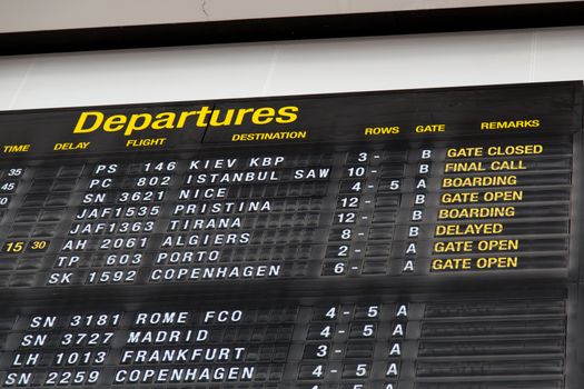 Airport departure board in terminal with flight information