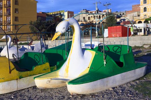 COPACABANA, BOLIVIA - OCTOBER 17, 2014: White and green swan shaped pedal boat on the shore of Lake Titicaca in the small tourist town on October 17, 2014 in Copacabana, Bolivia. Many pedal boats and kayaks are available for rent along the coastline of Copacabana. 