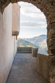 Ancient stone window that shows part of landscape