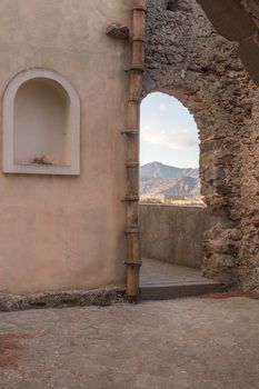 Ancient stone window that shows part of landscape