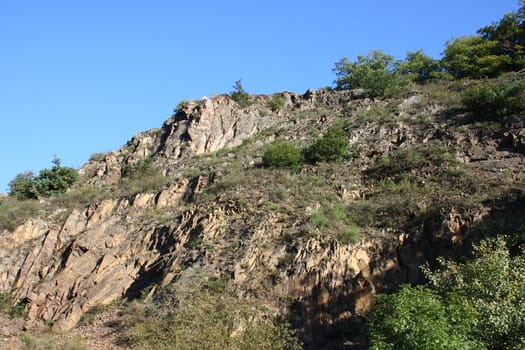 A landscape in the highlands, with rocks, trees and blue sky