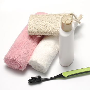 towel loofah liquid soap and toothbrush on a white background