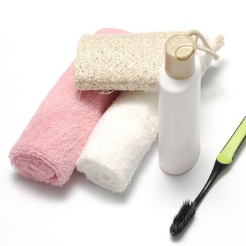towel loofah liquid soap and toothbrush on a white background