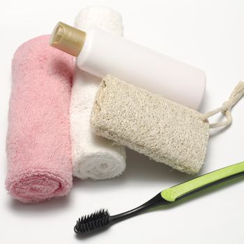 towel loofah liquid soap and toothbrush on a white background