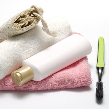 towel loofah liquid soap and toothbrush on a white background