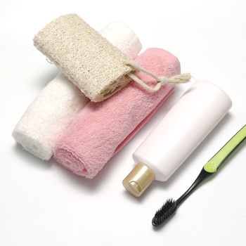 towel loofah liquid soap and toothbrush on a white background