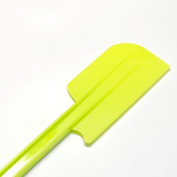 green plastic spatula on a white background