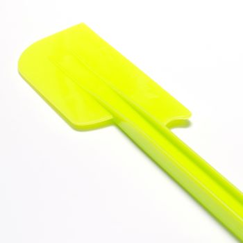 green plastic spatula on a white background