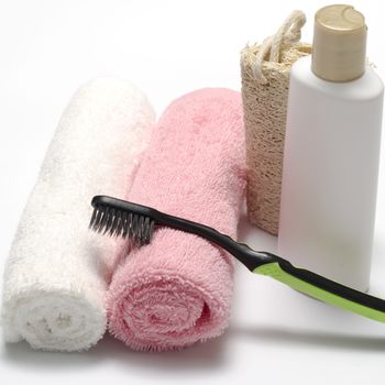 towel loofah liquid soap and toothbrush on a white background
