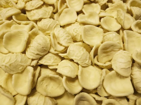 Close-up view of fresh hand made pasta orecchiette from Apulia South Italy. For restaurant and traditional Italian food background.