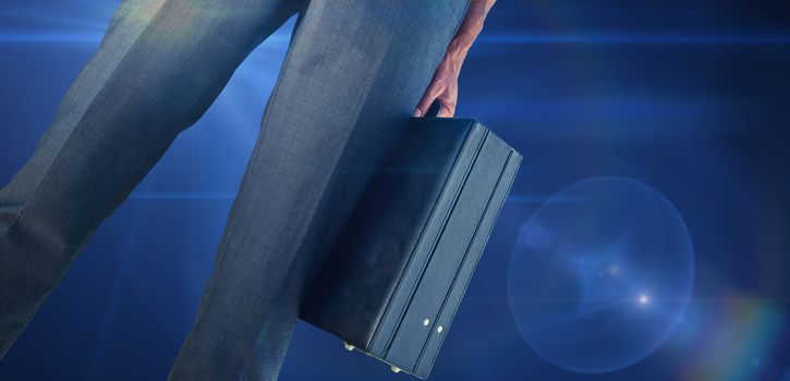 Composite image of businessman holding briefcase against blue spark 
